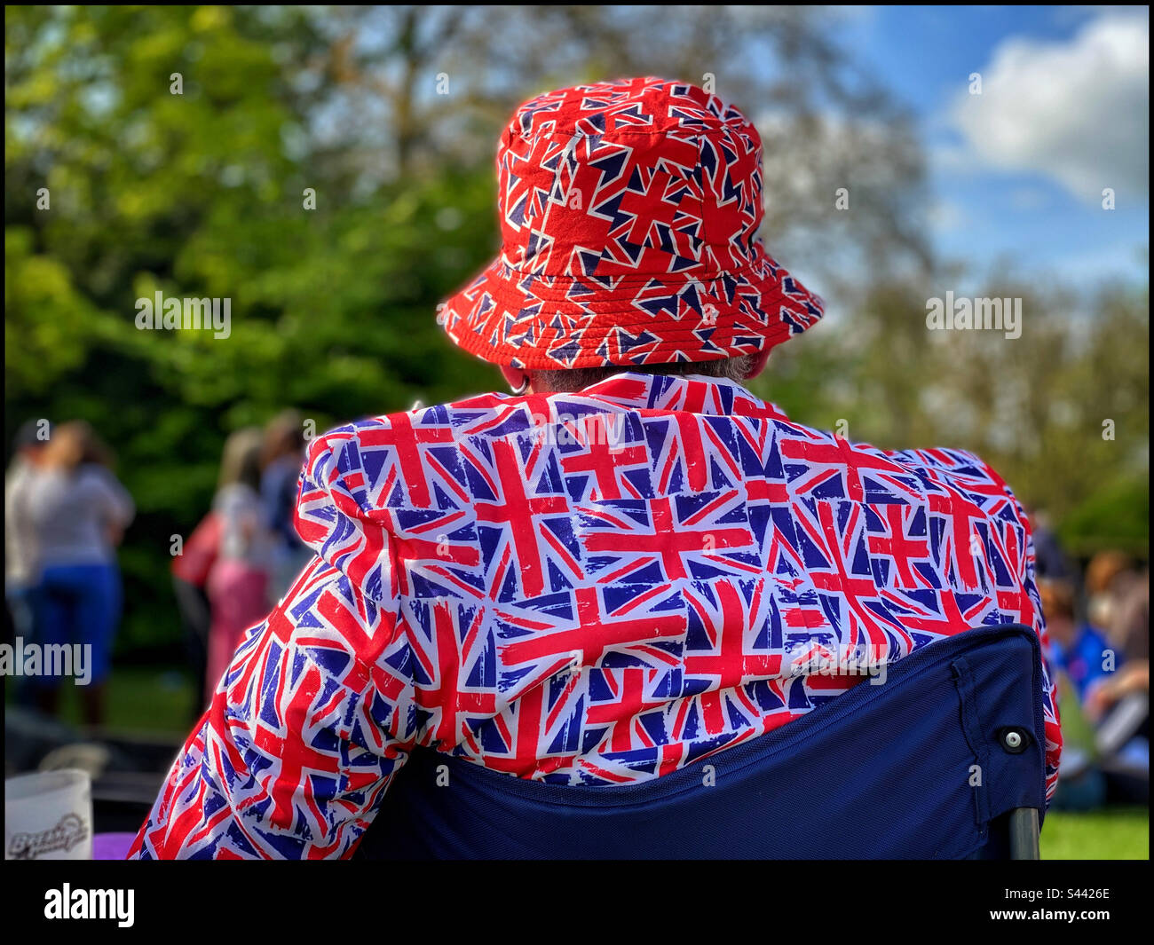 Un Britannique patriotique porte une veste et un chapeau ornés d'images du drapeau de l'Union Jack en mai 2023 pour célébrer le couronnement du roi Charles III et de la reine Camila. Photo ©️ COLIN HOSKINS. - Image de stock capturée avec un smartphone