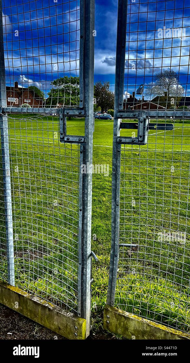 Porte métallique menant à un terrain de football en herbe Banque D'Images