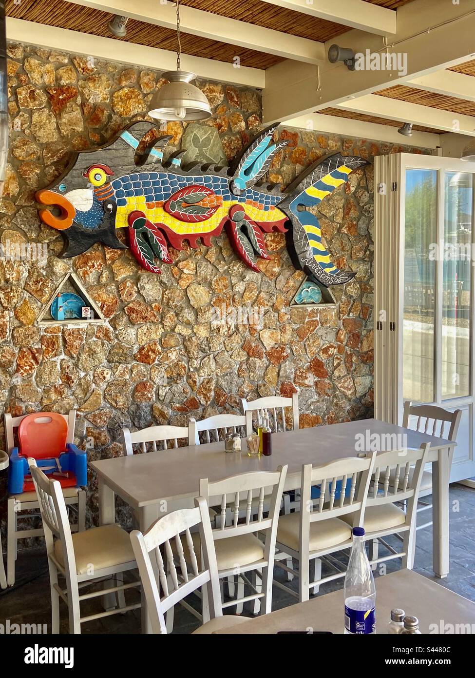 Taverne grecque traditionnelle avec poisson en bois coloré, table et chaises Banque D'Images