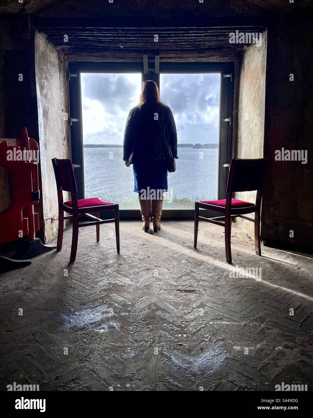 Silhouette de femme seule qui regarde la mer par la fenêtre - Image de stock capturée avec un smartphone