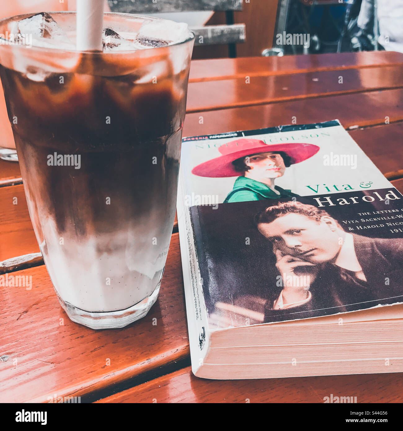 Un café glacé et un livre Banque D'Images