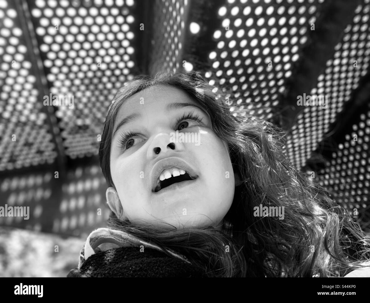 Enfant, fille jouant sous les escaliers avec la bouche ouverte dans le gaz. Banque D'Images