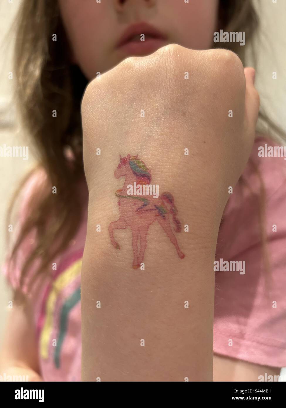 Tatouage temporaire d'une licorne sur un poignet de fille Banque D'Images