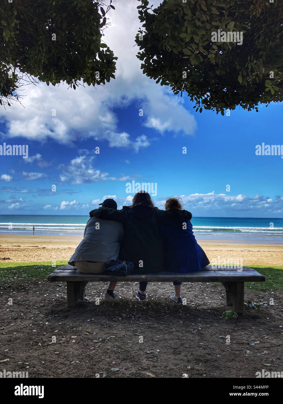 Trois personnes se sont assises sur un banc à Lorne Beach Victoria, en Australie Banque D'Images