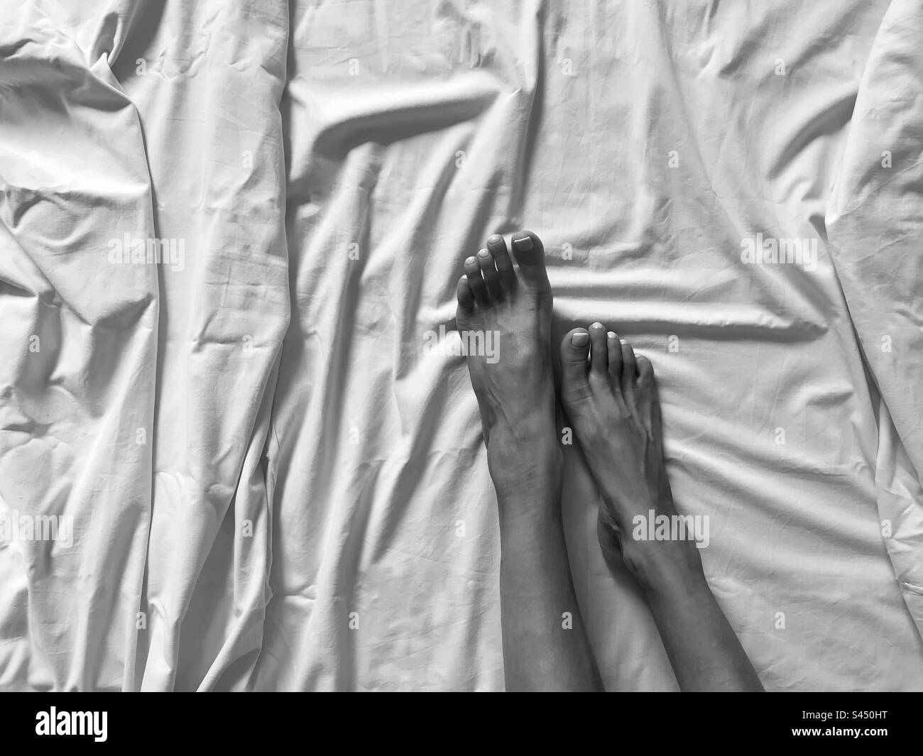 Pieds de femme dans le lit noir et blanc - Image de stock capturée avec un smartphone Pieds de femme dans le lit noir et blanc - Image de stock capturée avec un smartphone