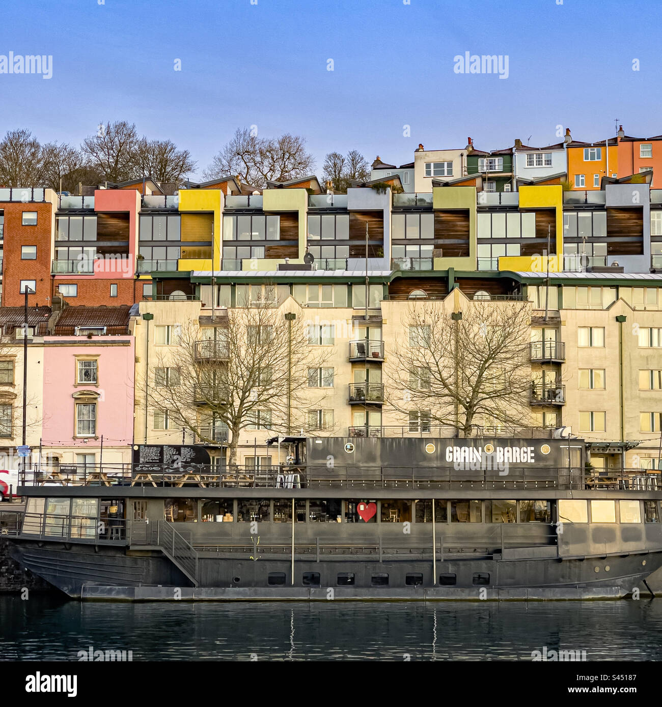 Péniche à grains avec des maisons traditionnelles et contemporaines colorées derrière. Port de plaisance de Bristol. ROYAUME-UNI - Image de stock capturée avec un smartphone