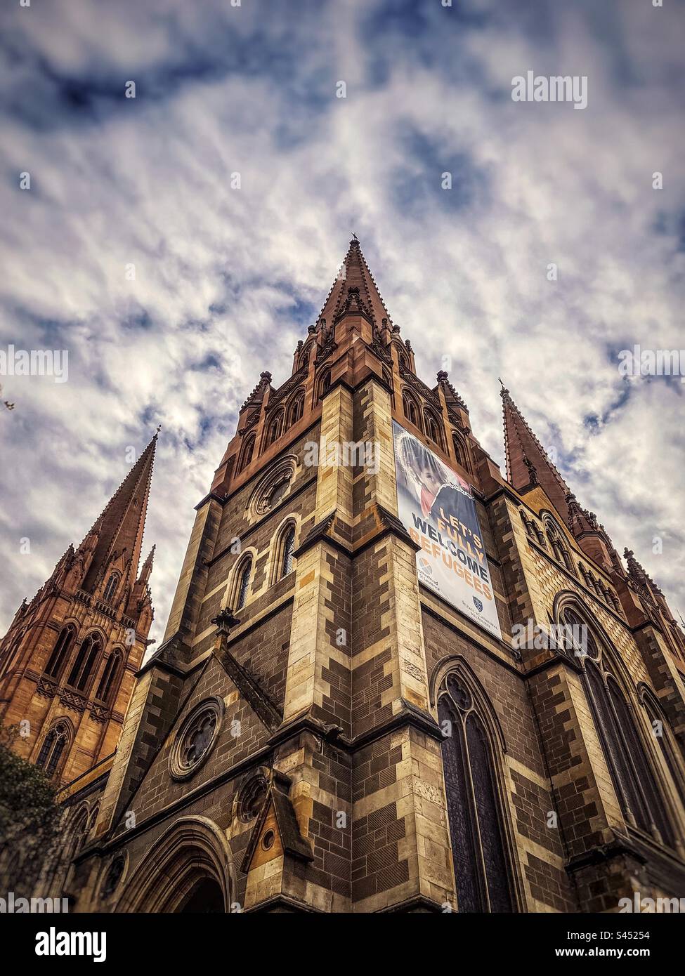 Vue à angle bas de St. Paul’s Cathedral, Melbourne, Victoria, Australie contre un ciel nuageux et lumineux. Banque D'Images