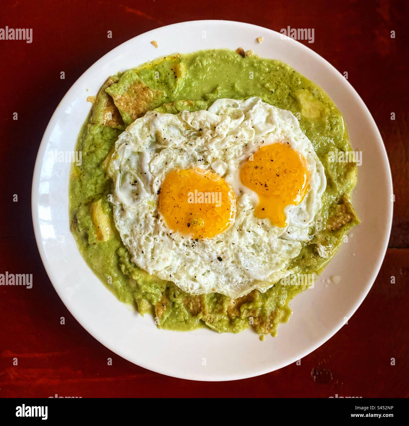 Deux œufs sur le dessus de chilaquiles verdes avec une sauce tomate verte pour le petit déjeuner à Queretaro, Mexique Banque D'Images
