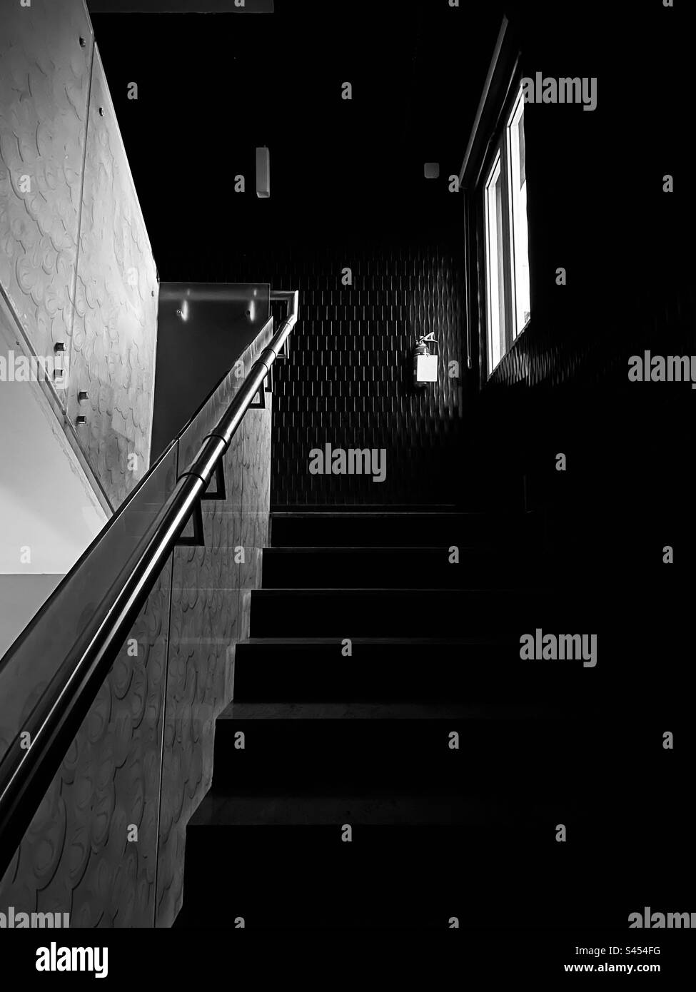Image noire et blanche des escaliers avec lumière venant de la fenêtre Banque D'Images