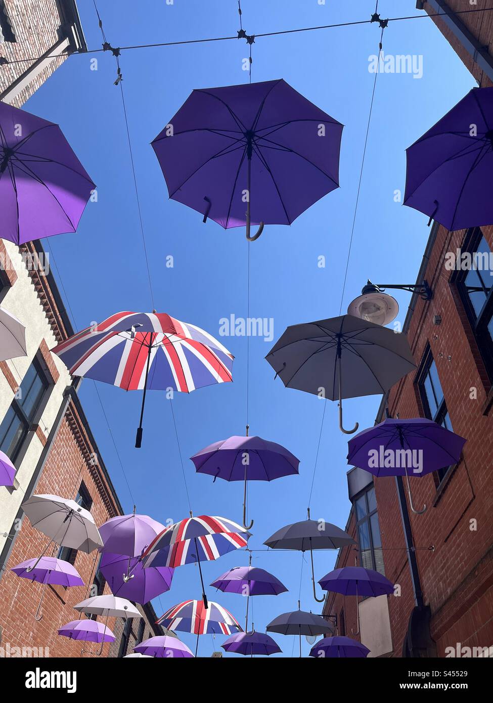 Parapluie aérien, photographié contre un ciel bleu d'été, avec des  parapluies à motif Union Jack, entre deux rangées de bâtiments Photo Stock  - Alamy