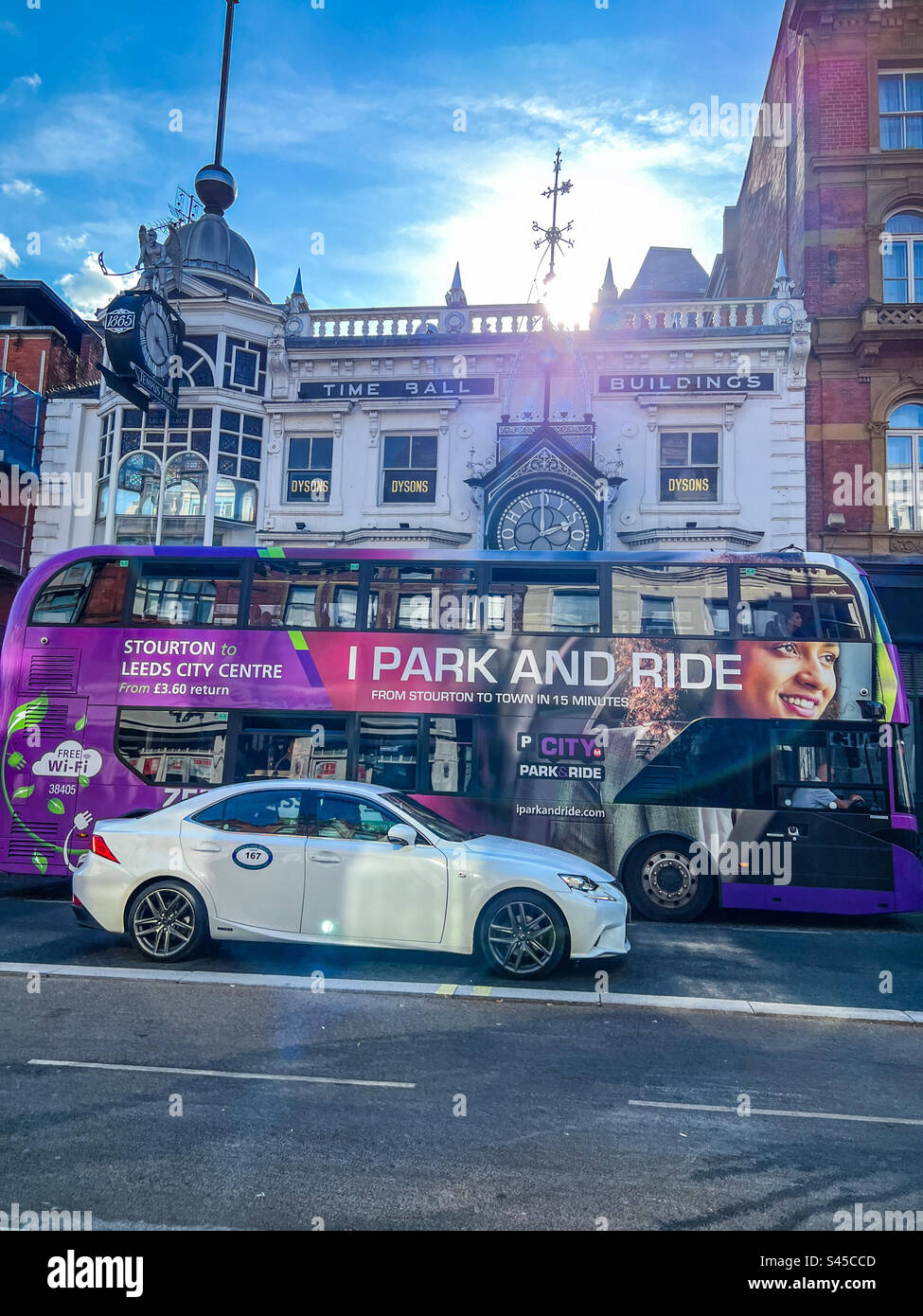 Taxi et bus privés sur Briggate à côté des bâtiments Time ball dans le centre-ville de Leeds Banque D'Images