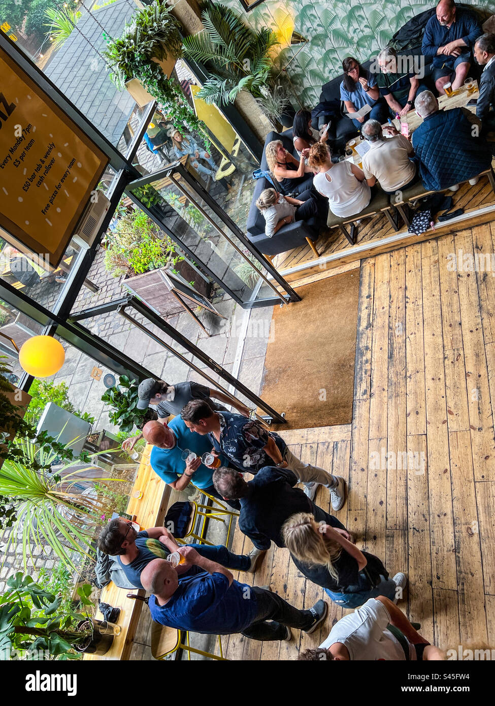 Les gens s'amusent à l'intérieur du bar animé dans le centre-ville de Leeds Banque D'Images