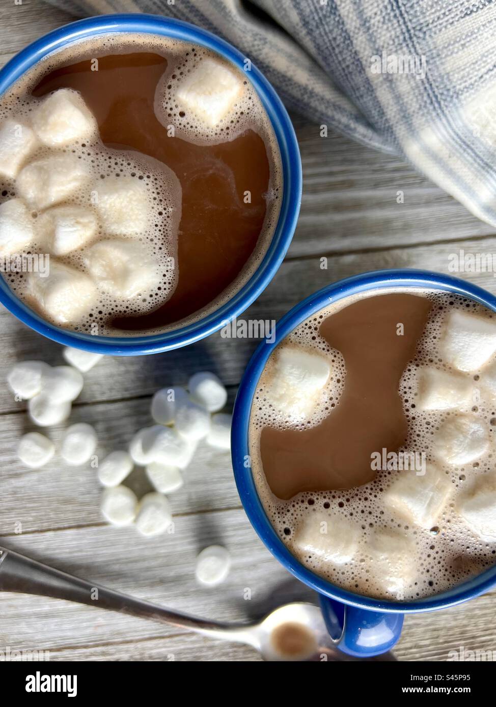 Cacao chaud avec guimauves dans des tasses bleues Banque D'Images