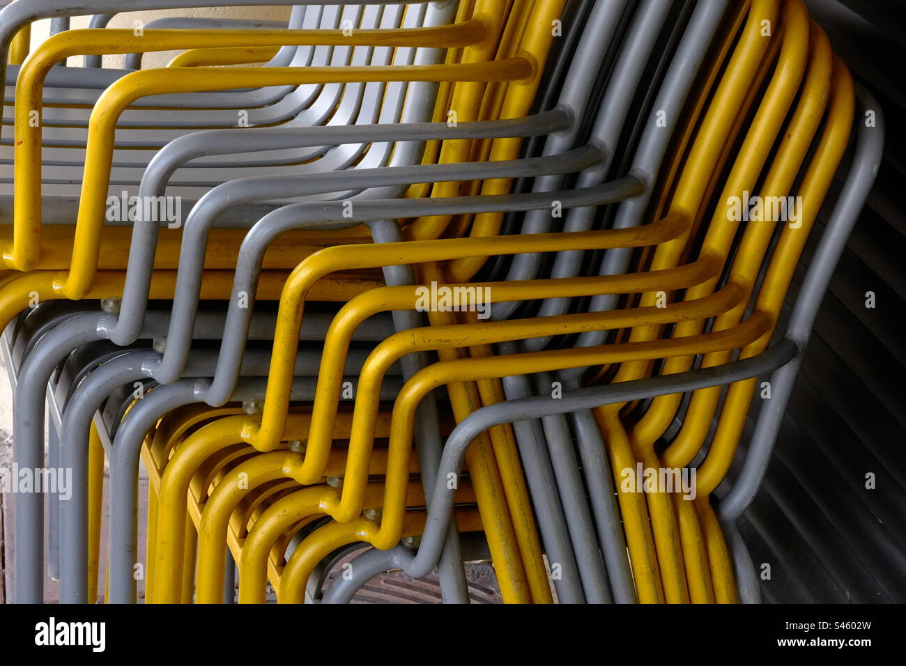 Pile. De chaises jaunes et grises Banque D'Images