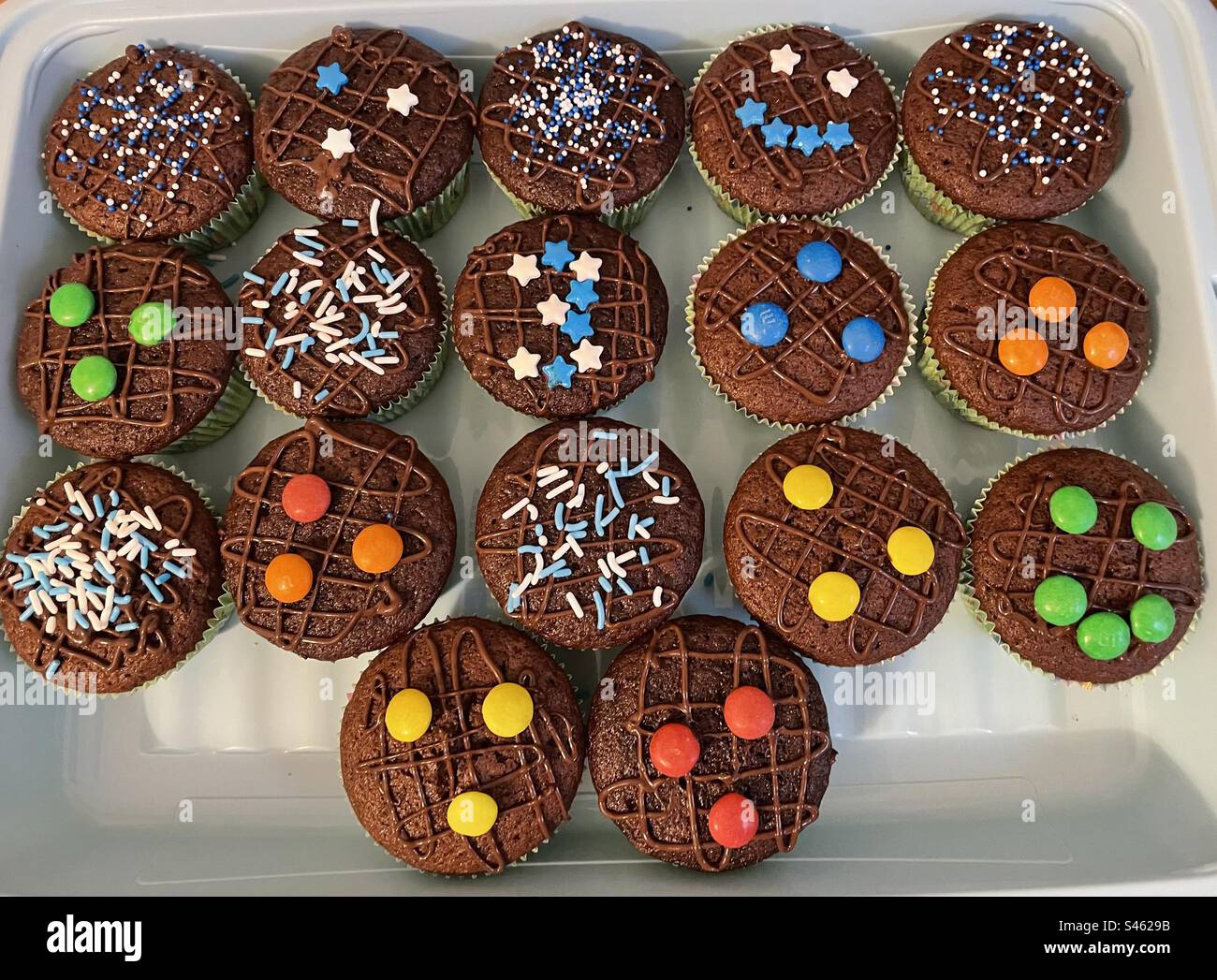 Muffin au chocolat avec des bonbons M&M, dont un avec un visage souriant Banque D'Images