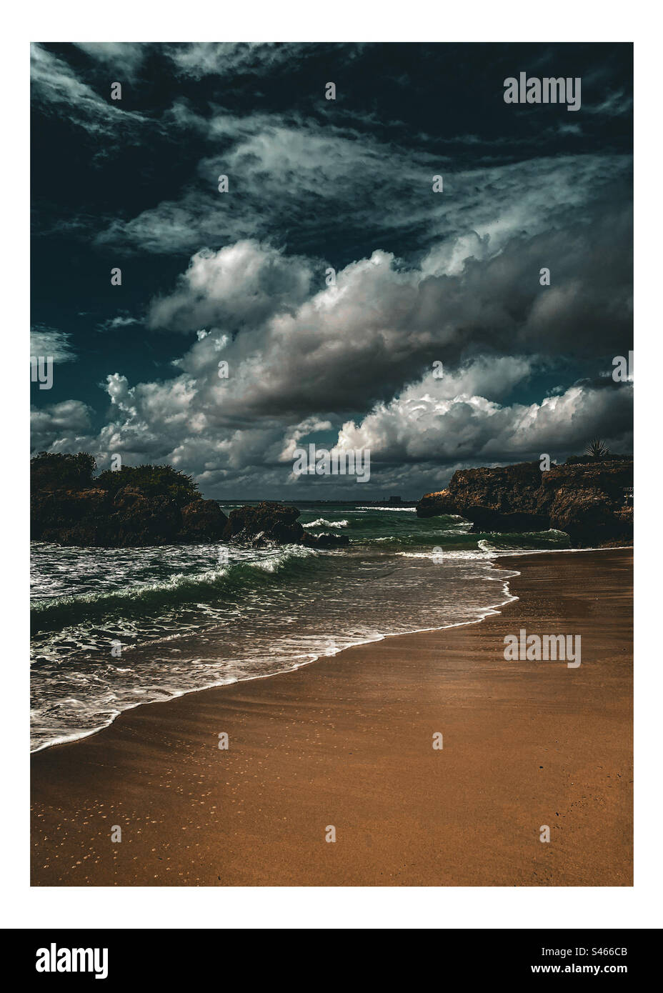 Une scène de plage nocturne dramatique avec des vagues et des nuages. Plage de sable sombre la nuit avec des vagues et un ciel nuageux dramatique lourd, Banque D'Images