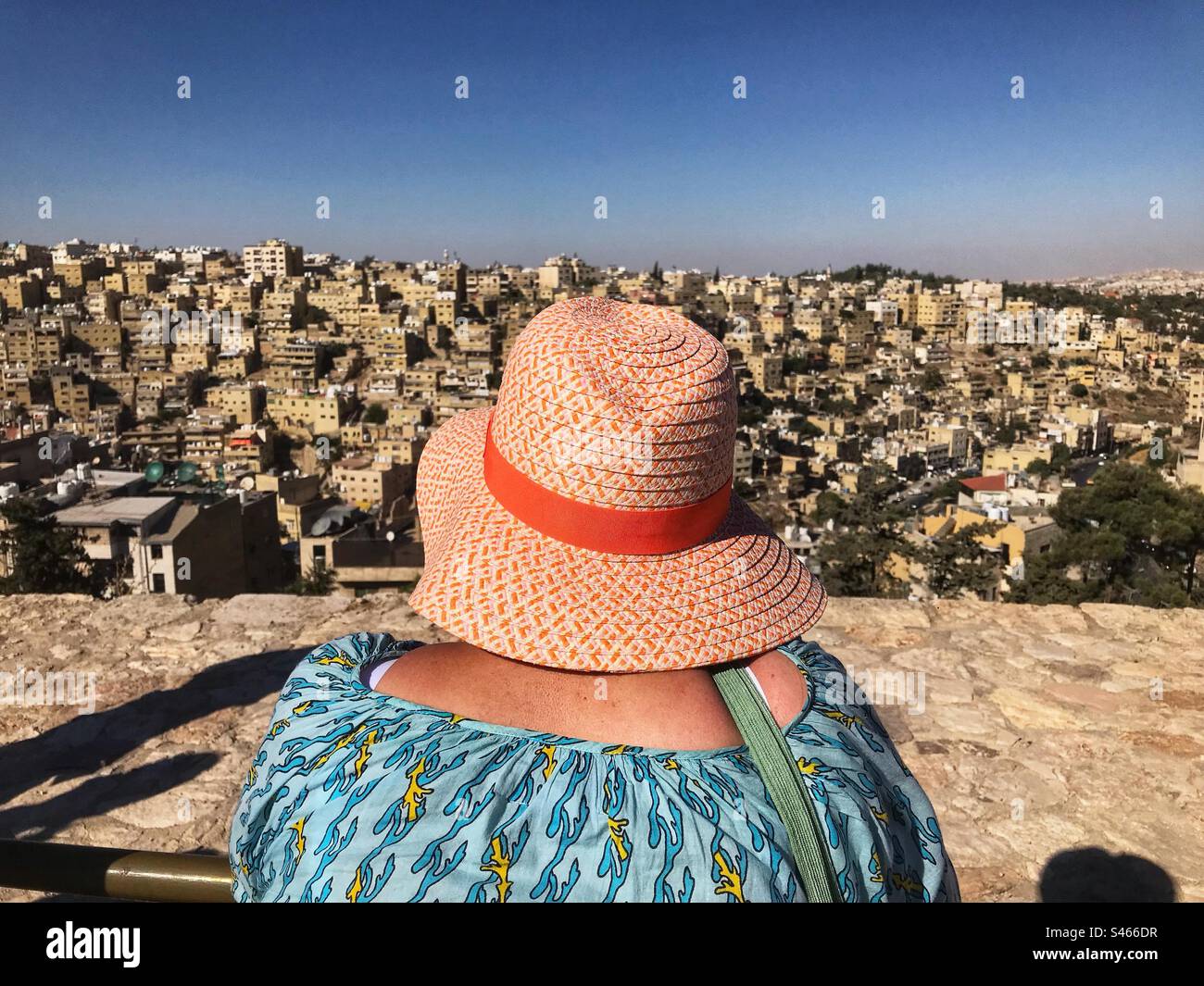 Amman Jordan une touriste portant un chapeau de soleil regarde une vue sur la banlieue vallonnée de la capitale jordanienne depuis la Citadelle - Image de stock capturée avec un smartphone Amman Jordan une touriste portant un chapeau de soleil regarde une vue sur la banlieue vallonnée de la capitale jordanienne depuis la Citadelle - Image de stock capturée avec un smartphone