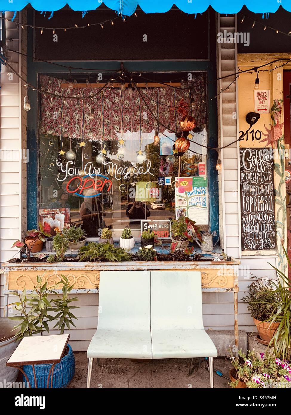 Extérieur de la maison de café avec banc blanc et plantes Banque D'Images