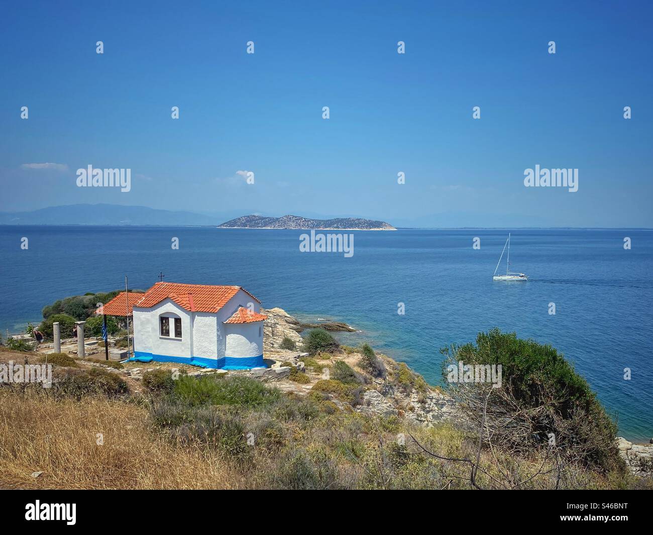 Vue sur la mer avec petite chapelle et l'île de Thasopoula près de Limenas sur l'île de Thassos, Grèce. Banque D'Images