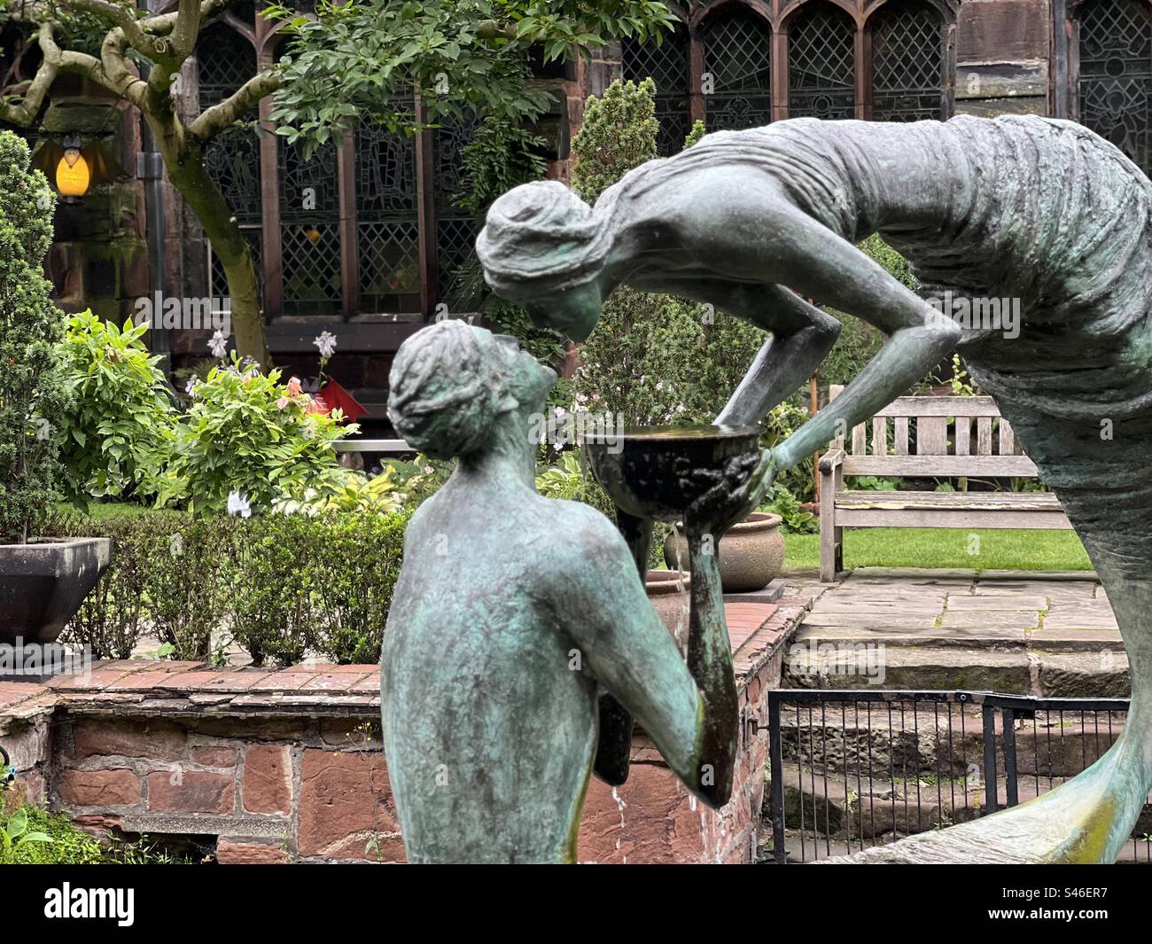 Statue en bronze de deux amoureux partageant la nourriture dans le jardin de la cathédrale de Chester Banque D'Images
