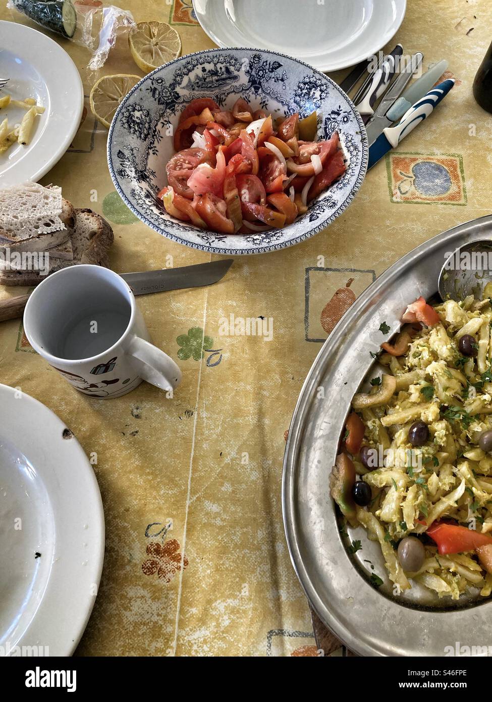 Repas portugais «bacalhau à Brás» (repas typique) et salade de tomates sur table. Avec couverts et vaisselle. Banque D'Images