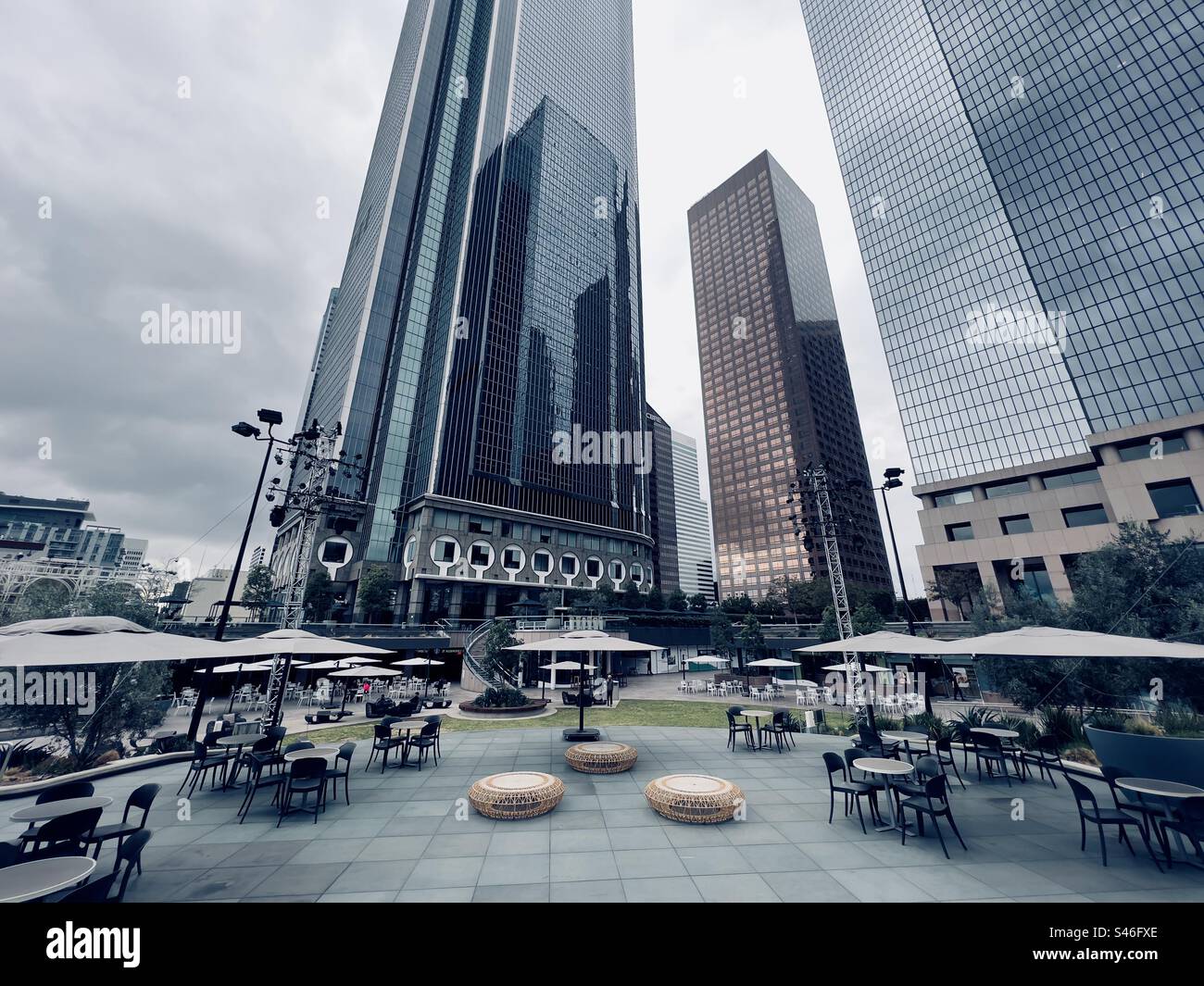 LOS ANGELES, CA, décembre 2022 : image horizontale de tables et de chaises disposées le jour couvert au California Plaza dans le quartier financier du centre-ville, les gratte-ciel atteignent le ciel en arrière-plan - Image de stock capturée avec un smartphone