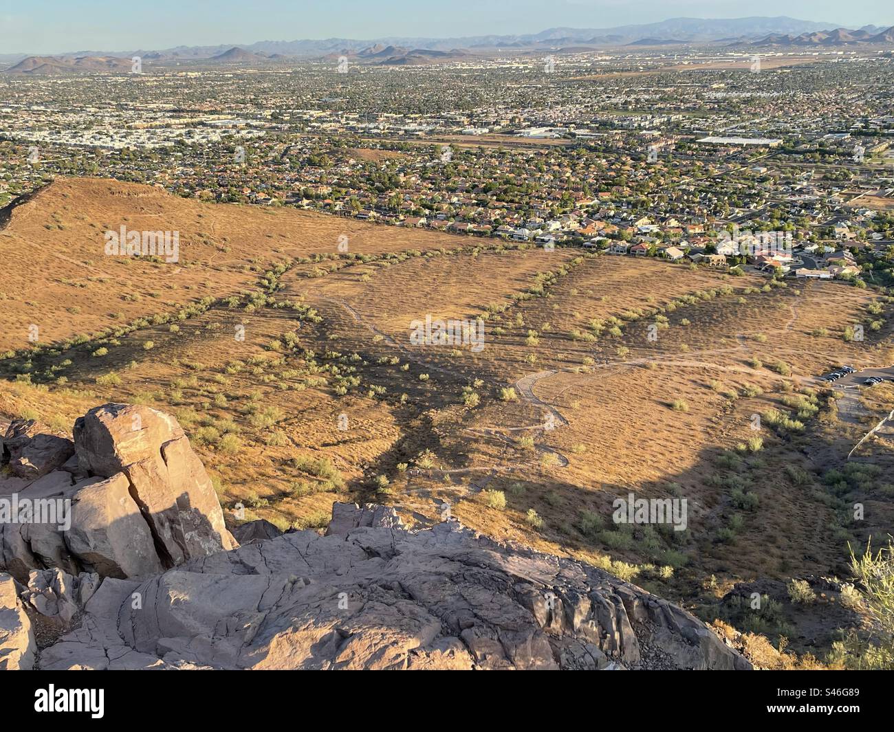 Nature tenant une ville à distance, vue depuis Lookout Mountain, falaises abruptes surplombant le sentier sinueux loin en dessous, 16th Street Trailhead, North Phoenix, Arizona Banque D'Images