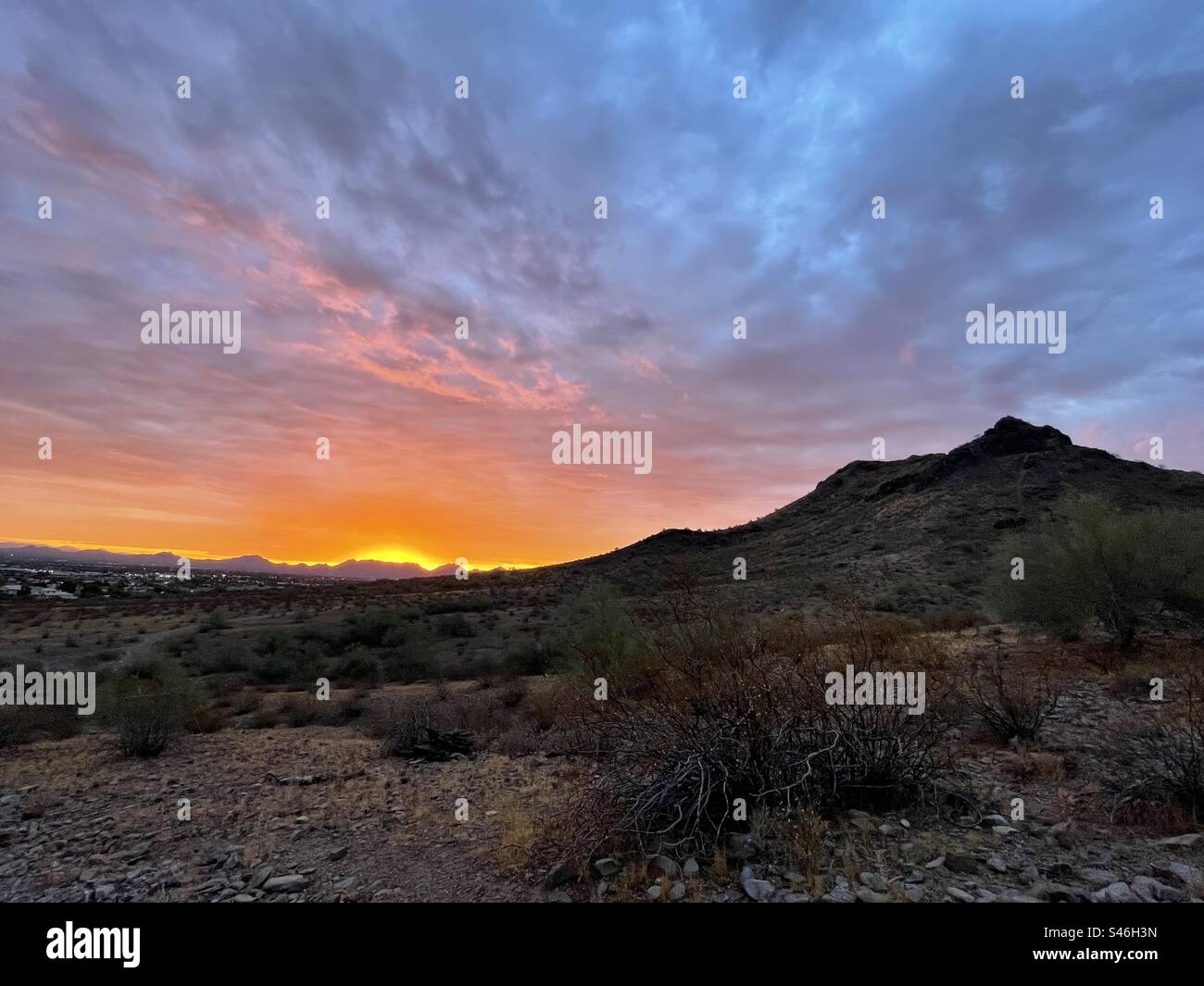 Un halo de soleil levant sur les montagnes McDowell, orange, violet, des rives de nuages en flammes de couleur, profil de Lookout Mountain, désert de Sonoran, Phoenix, Arizona Banque D'Images