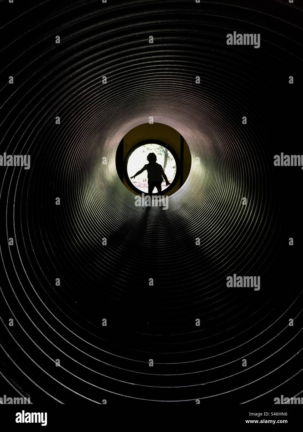 Enfant en bas âge dans une silloette tunnel noire Banque D'Images