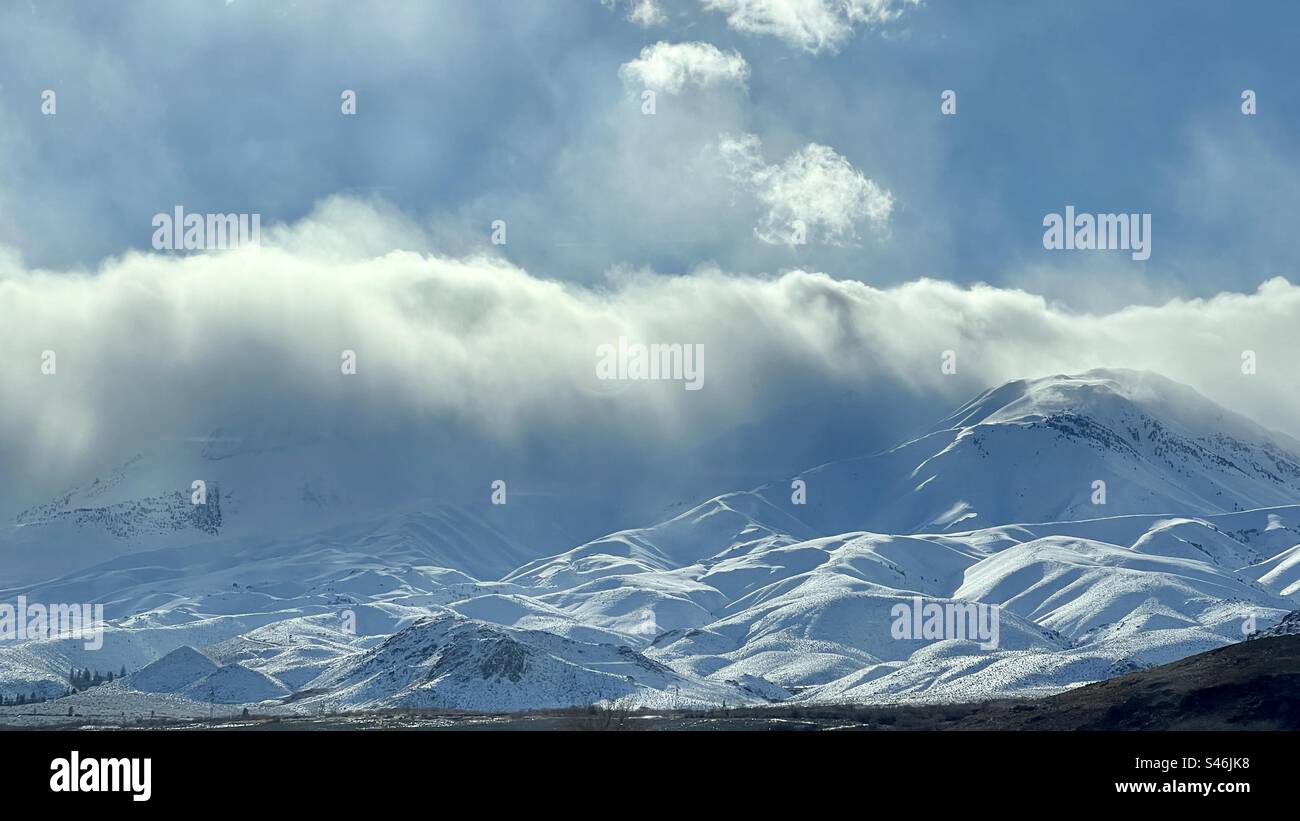 Nuages bas d'hiver roulant au-dessus des montagnes couvertes de neige - Image de stock capturée avec un smartphone