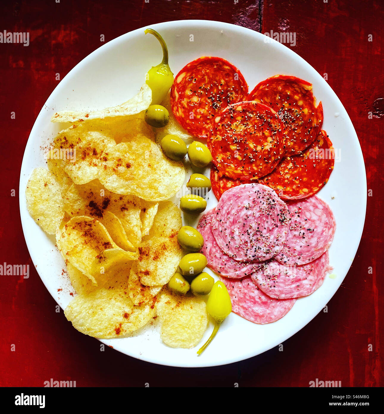 Pommes de terre frites avec piments rouges, olives, piments jaunes en cascade, salami et chorizo espagnol pour tapas à Queretaro, Mexique Banque D'Images