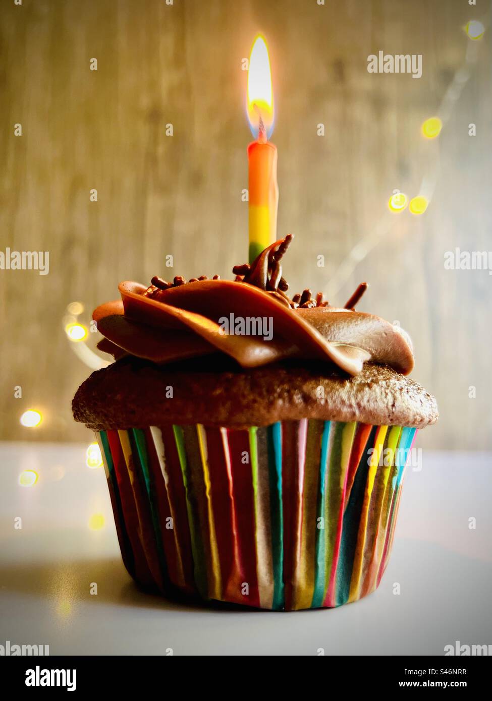 Gros plan d'un cupcake au chocolat avec bougie arc-en-ciel Banque D'Images