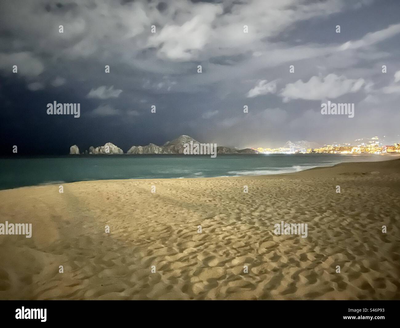 Beau paysage nocturne d'une plage à Cabo San Lucas, avec le bord de l'ouragan Hillary qui passe et des nuages sombres sur les maux de Cabo San Lucas Mexique et les lumières de la ville lumineuse de Cabo Banque D'Images