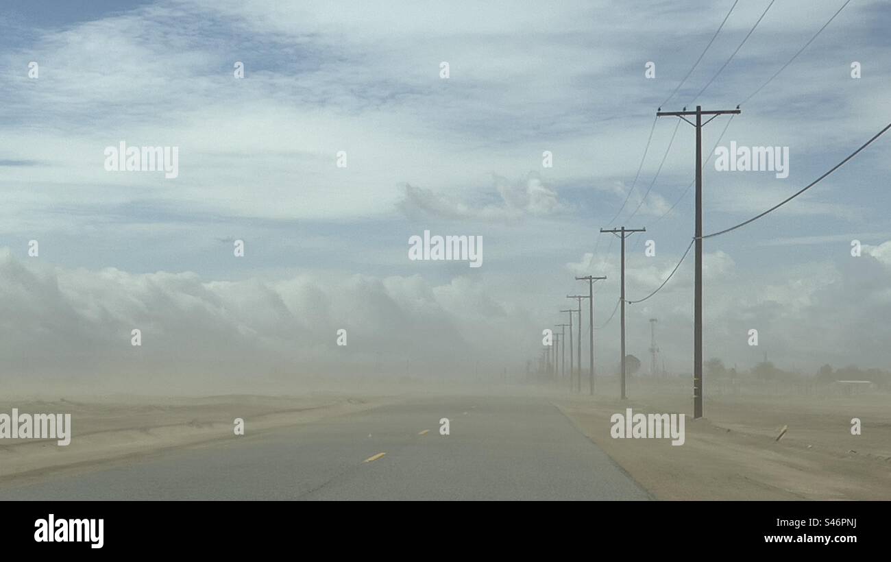 Tempête de poussière à vue large sur la route du désert dans le sud de la Californie, avec des poteaux télégraphiques sur le côté de la route, s'estompant dans la distance Banque D'Images Tempête de poussière à vue large sur la route du désert dans le sud de la Californie, avec des poteaux télégraphiques sur le côté de la route, s'estompant dans la distance Banque D'Images