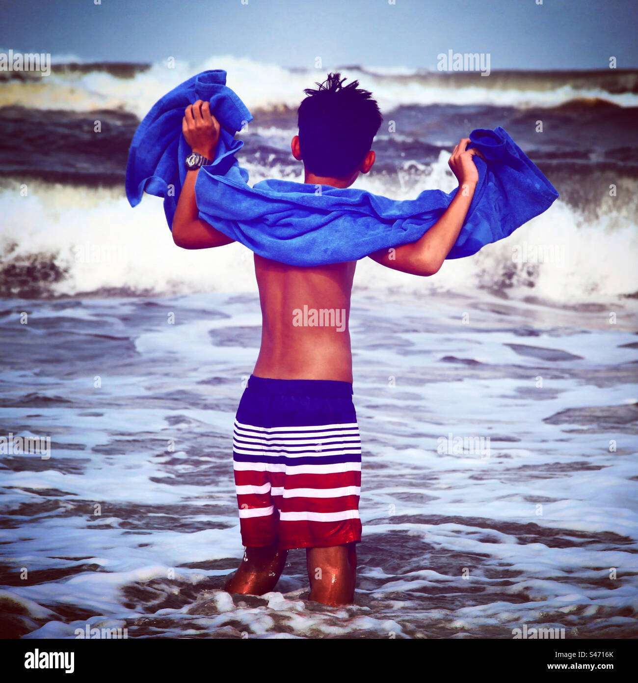 petit garçon face aux vagues de la mer en maillot de bain Banque D'Images