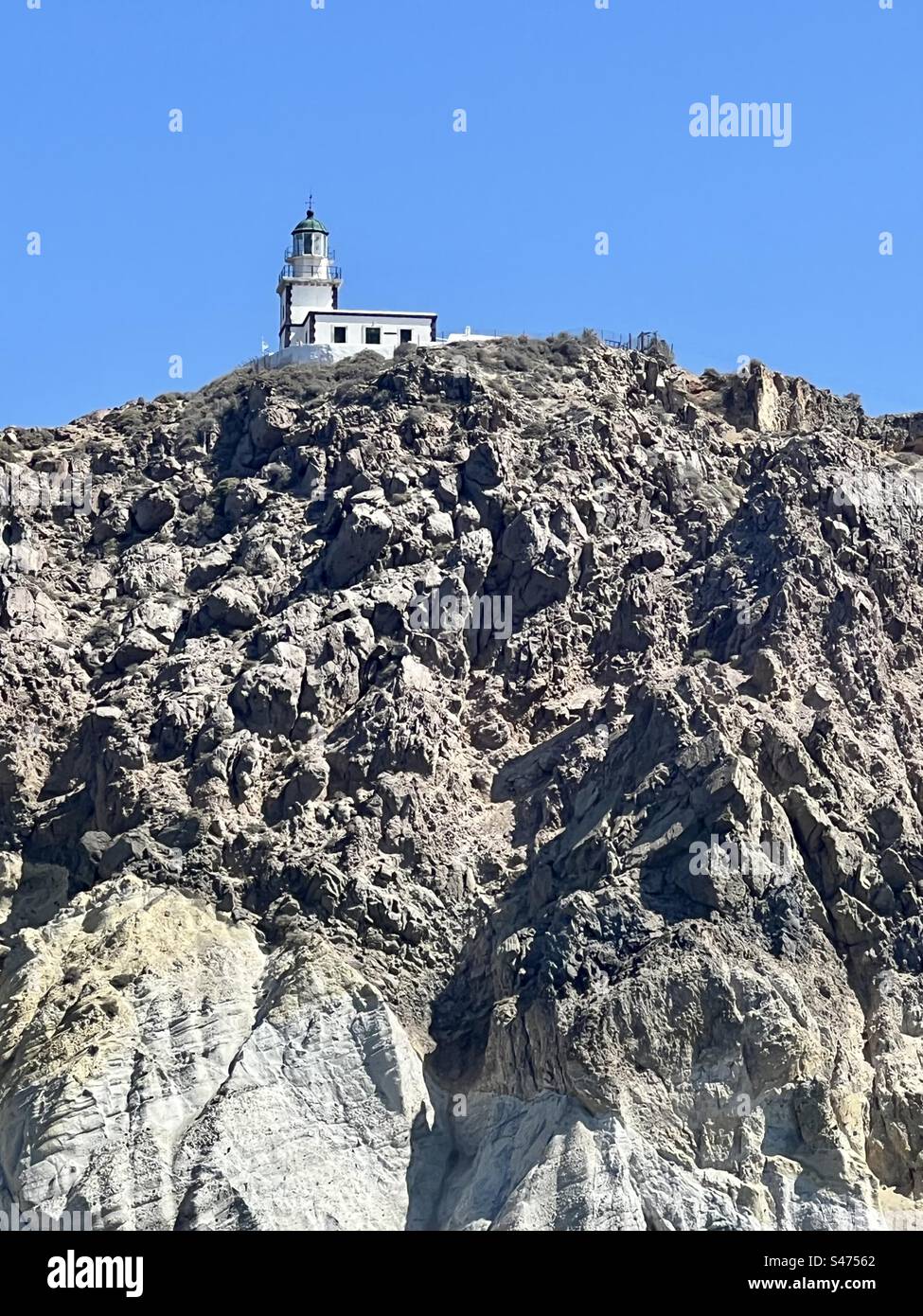 Le phare d'Akrotiri se trouve au sommet de la roche volcanique au-dessus de la caldeira de Santorin - Image de stock capturée avec un smartphone