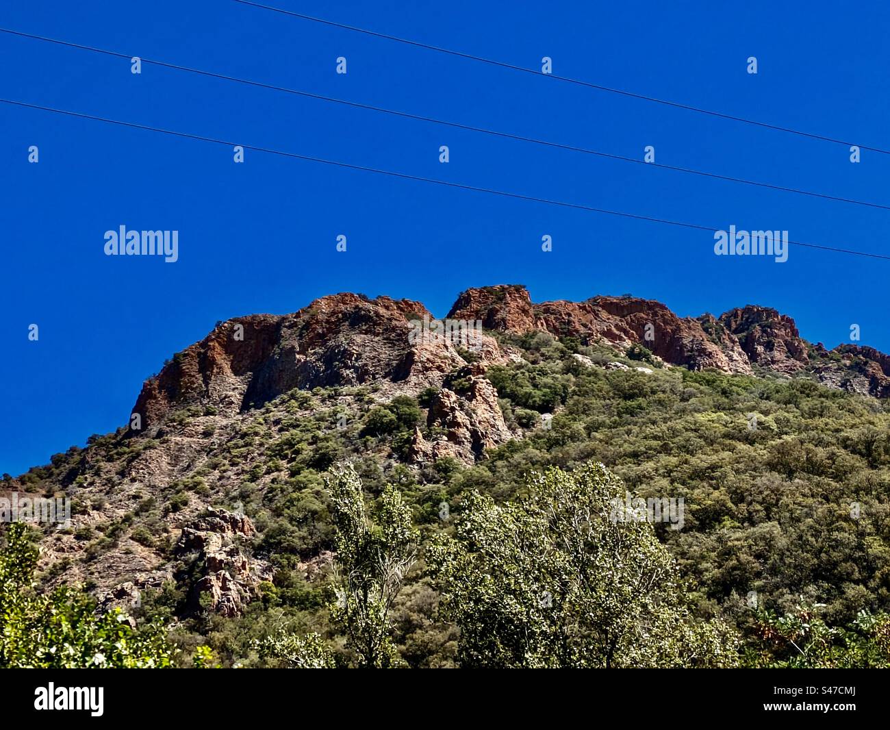 Montagnes Rocheuses collines du sud de la France lignes électriques pylônes arbres nature bord de route soleil ciel ensoleillé Banque D'Images