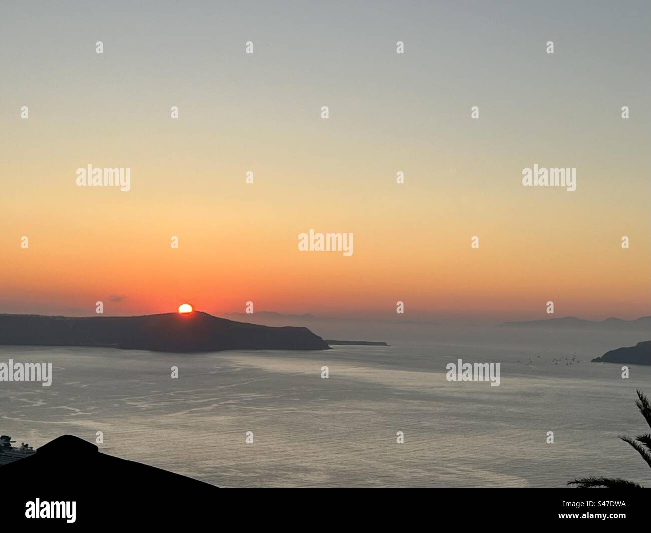 Coucher de soleil d'or et d'orange sur la mer Égée, vue de Fira , Santorin - Image de stock capturée avec un smartphone