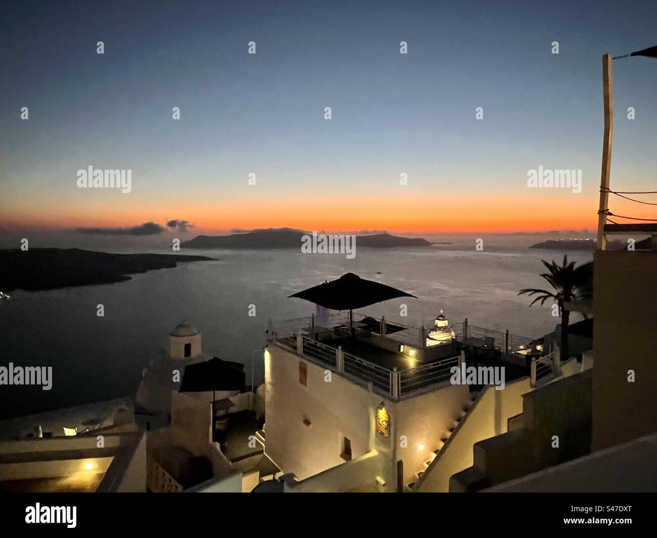 Vue sur le coucher du soleil et bâtiments illuminés le soir sur Santorin - Image de stock capturée avec un smartphone