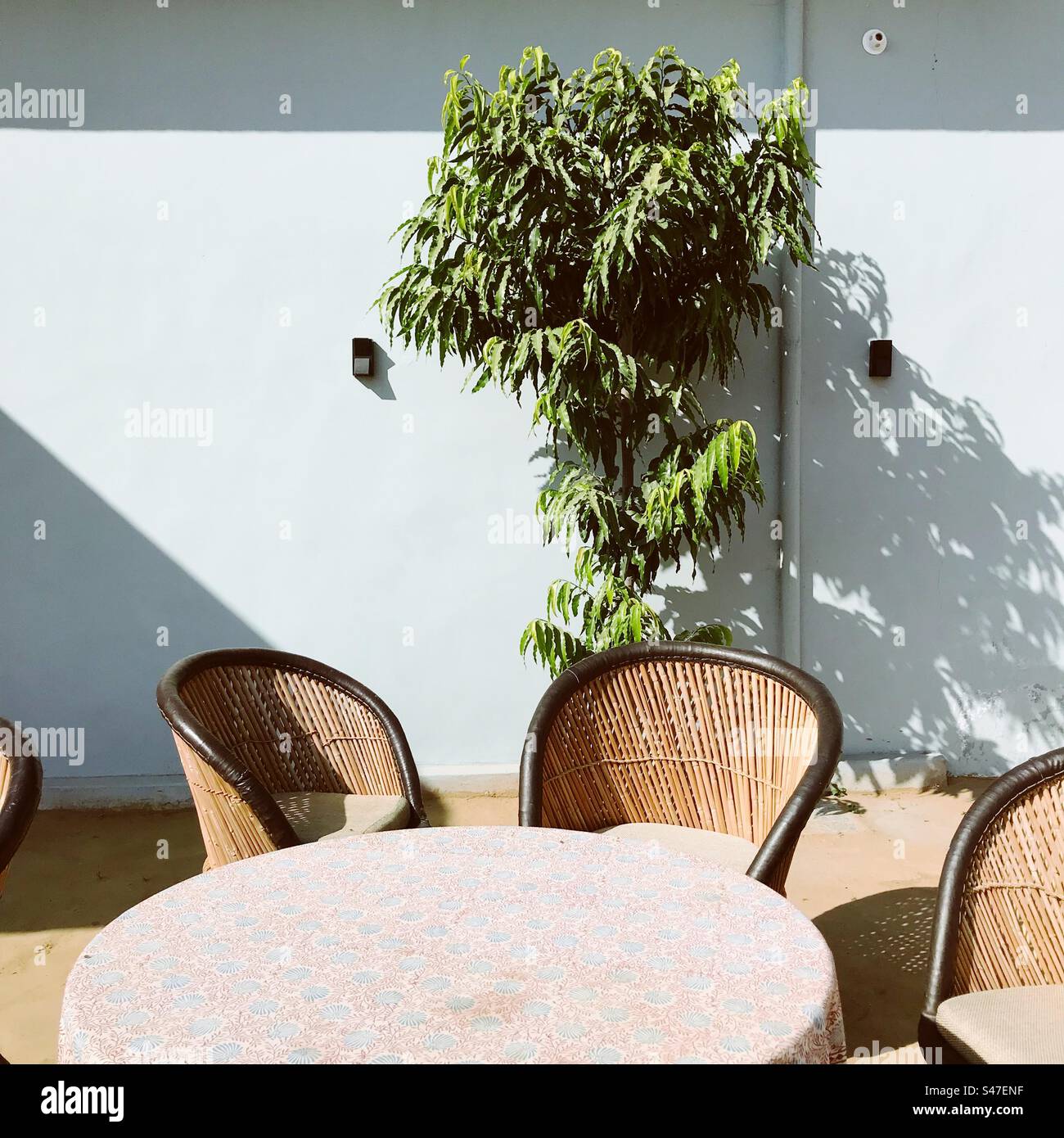 Chaises faites de cain autour d'une table à un coin salon extérieur Banque D'Images