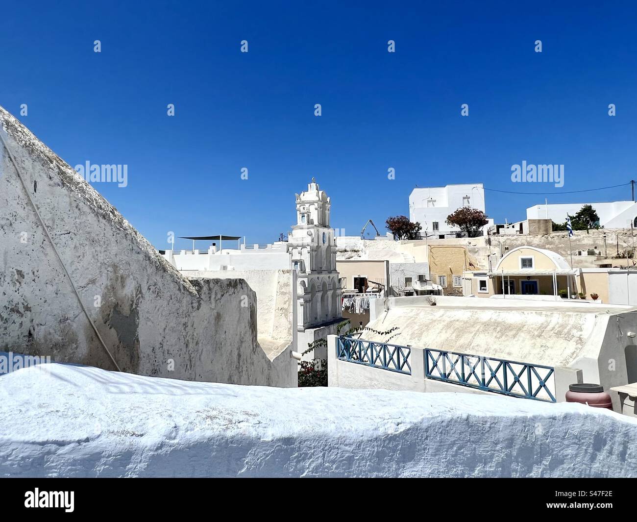 Vue vers le bas depuis un sentier juste au-dessus du centre du village de Megalochori à Santorin, avec son célèbre clocher. Banque D'Images