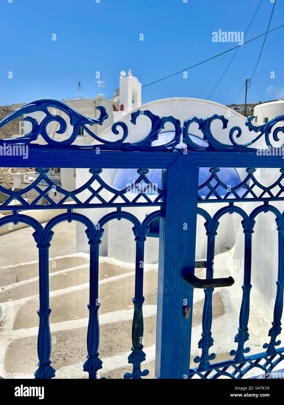 Porte peinte en bleu, escaliers, et une petite chapelle en dôme bleu et son clocher dans une rue latérale à Akotiri, Santorin, par une belle journée d'été. Banque D'Images