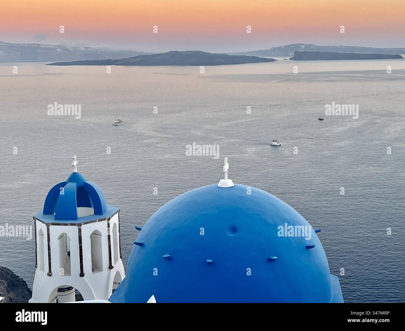 Eglise dôme bleu Spyridon et clocher à Oia, Santorin au coucher du soleil. - Image de stock capturée avec un smartphone