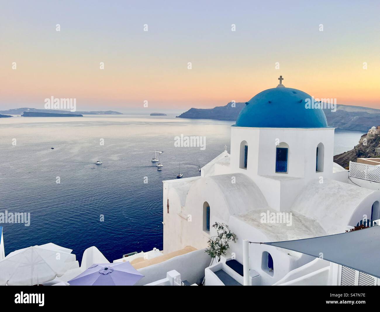St. Anastasi église dôme bleu à Oia, Santorin au coucher du soleil. - Image de stock capturée avec un smartphone