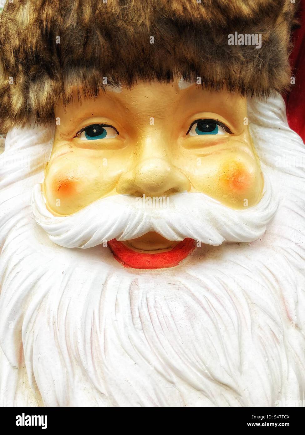 Gros plan sur le visage heureux du Père Noël avec une barbe blanche touffue et des joues rouges rosées Banque D'Images