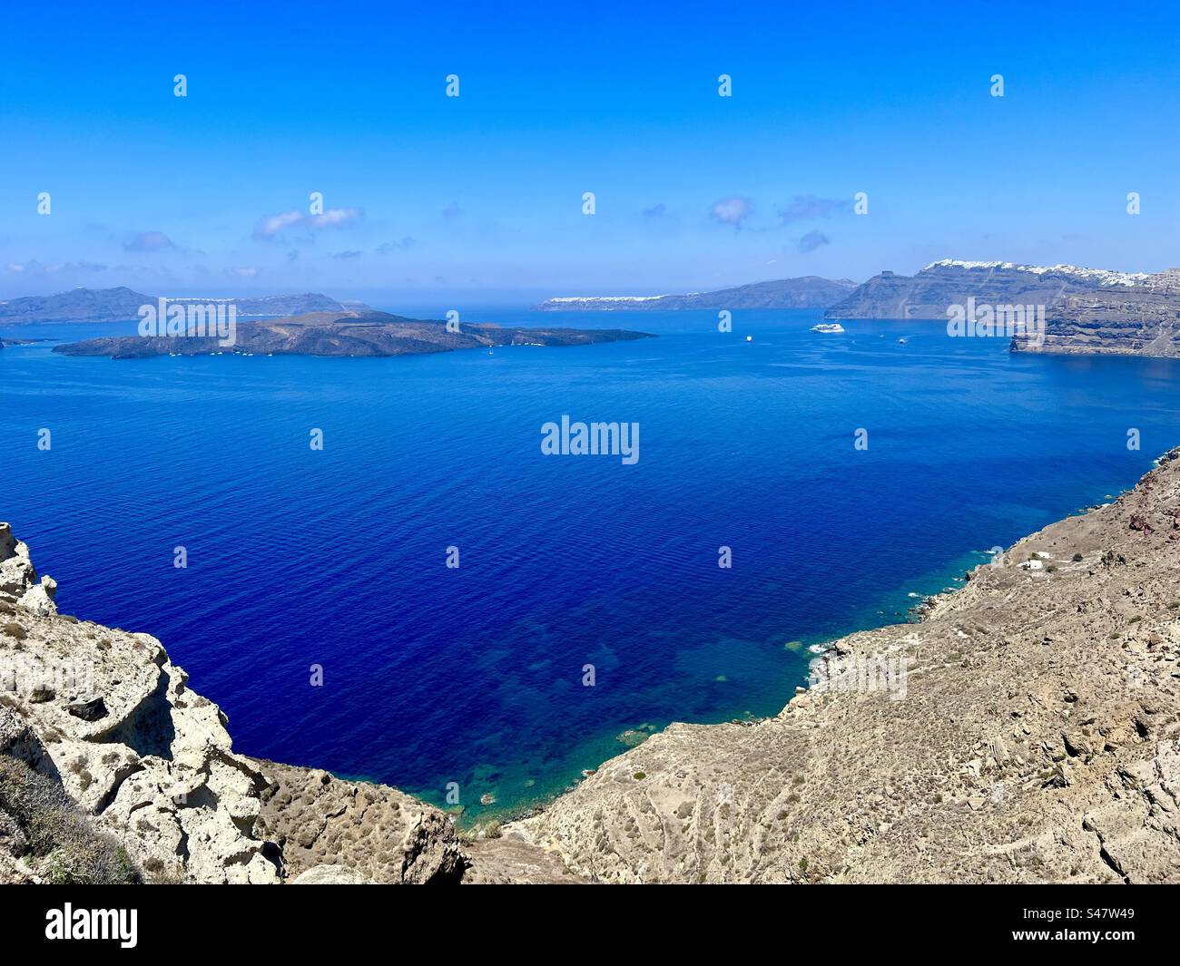 Beau ciel bleu et vue sur la mer Égée depuis les falaises de la caldeira à Megalochori, Santorin. Banque D'Images