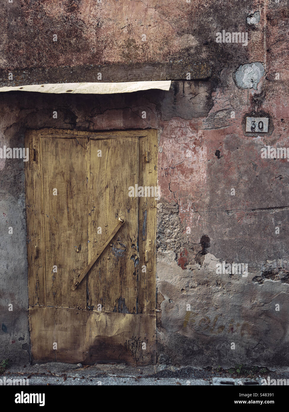 Rustique bien utilisé porte d'entrée à un atelier de rue arrière. Montechiaro, Vico Equense, Sorrente, Italie - Image de stock capturée avec un smartphone