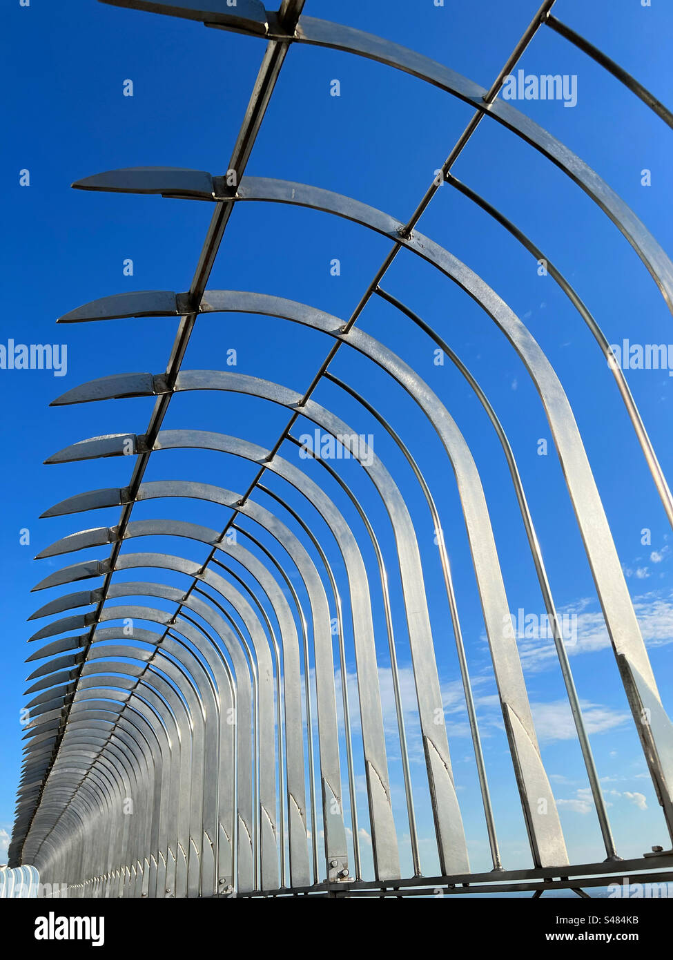 Résumé des clôtures de sécurité sur l'Empire State Building contre un ciel bleu vif Banque D'Images