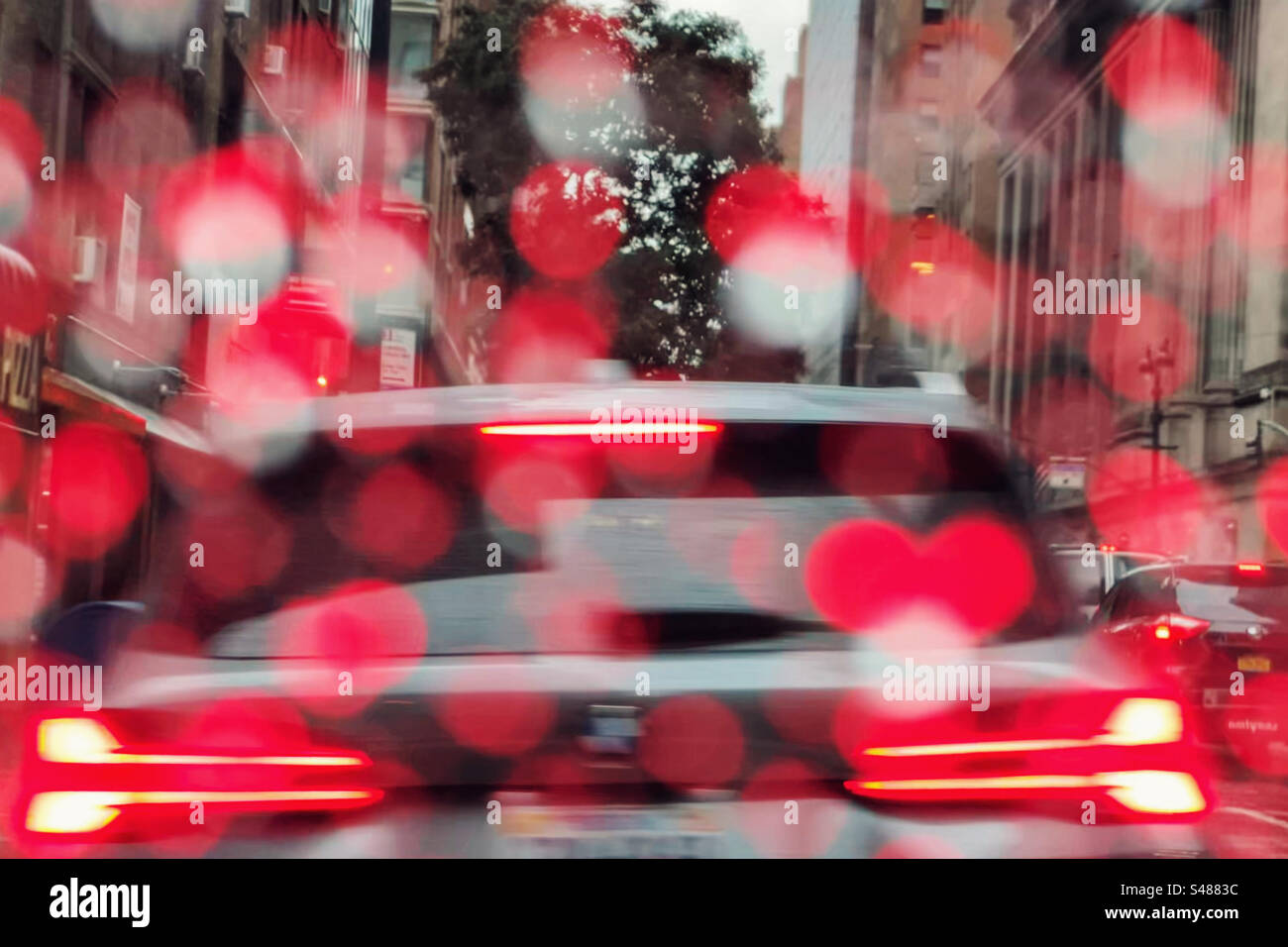 Feux stop et stop rouges réfléchis par des gouttes de pluie sur le pare-brise de la voiture, pris dans la circulation, Manhattan New York Banque D'Images