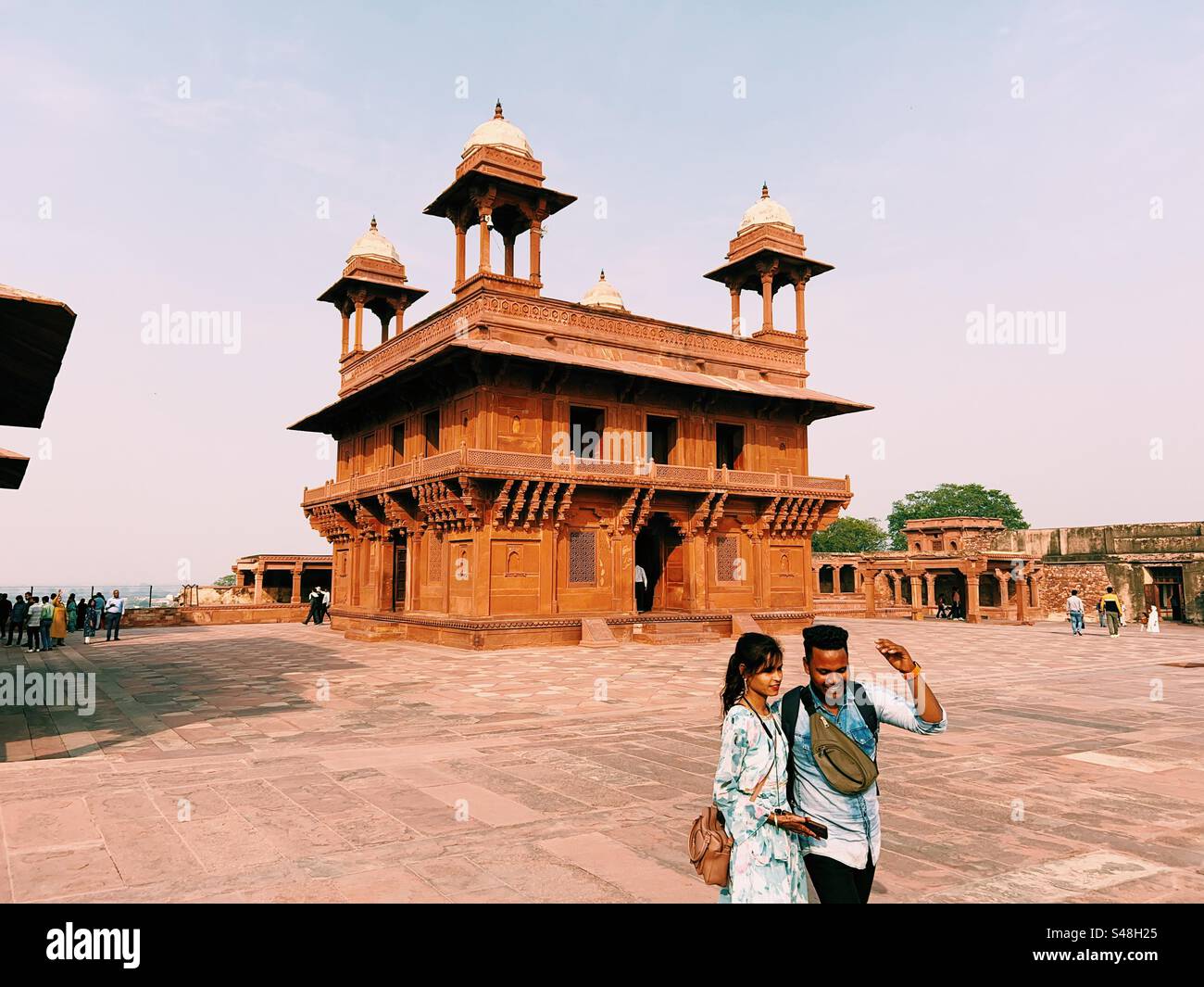 Un jeune couple indien appréciant le site historique de Fatehpur Sikri, un site classé au patrimoine mondial de l’UNESCO, en face du palais d’Akbar - Image de stock capturée avec un smartphone